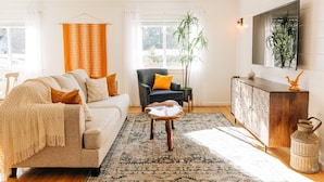 Ein Wohnzimmer mit einer Couch, Sesseln, einem Couchtisch und einem Schrank.