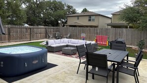 A backyard with a hot tub, outdoor furniture, and a basketball hoop. - A Family Cozy Getaway 7 miles from Sea World and Fiesta, Texas (San Antonio)