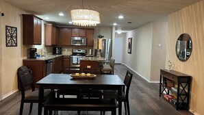 A modern kitchen with dark wood cabinets, stainless steel appliances, and a chandelier. - A Family Cozy Getaway 7 miles from Sea World and Fiesta, Texas (San Antonio)