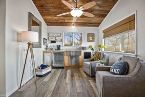Enjoy a spacious living area with a modern kitchen, sofa, and large window offering a view of the outdoors.