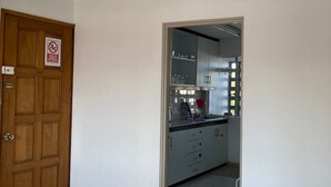 Een keuken met een roestvrijstalen afzuigkap, kastjes en een betegelde vloer.