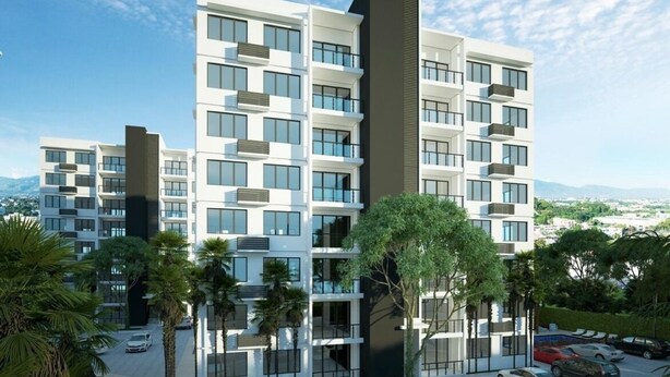 A multi-story residential building with balconies, a parking area, and surrounding greenery. - Confidence Luxurious Apartment (Santiago de los Caballeros)