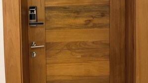 A wooden door with a metal handle and a keyhole, marked with a 'B' above it. - Confidence Luxurious Apartment (Santiago de los Caballeros)