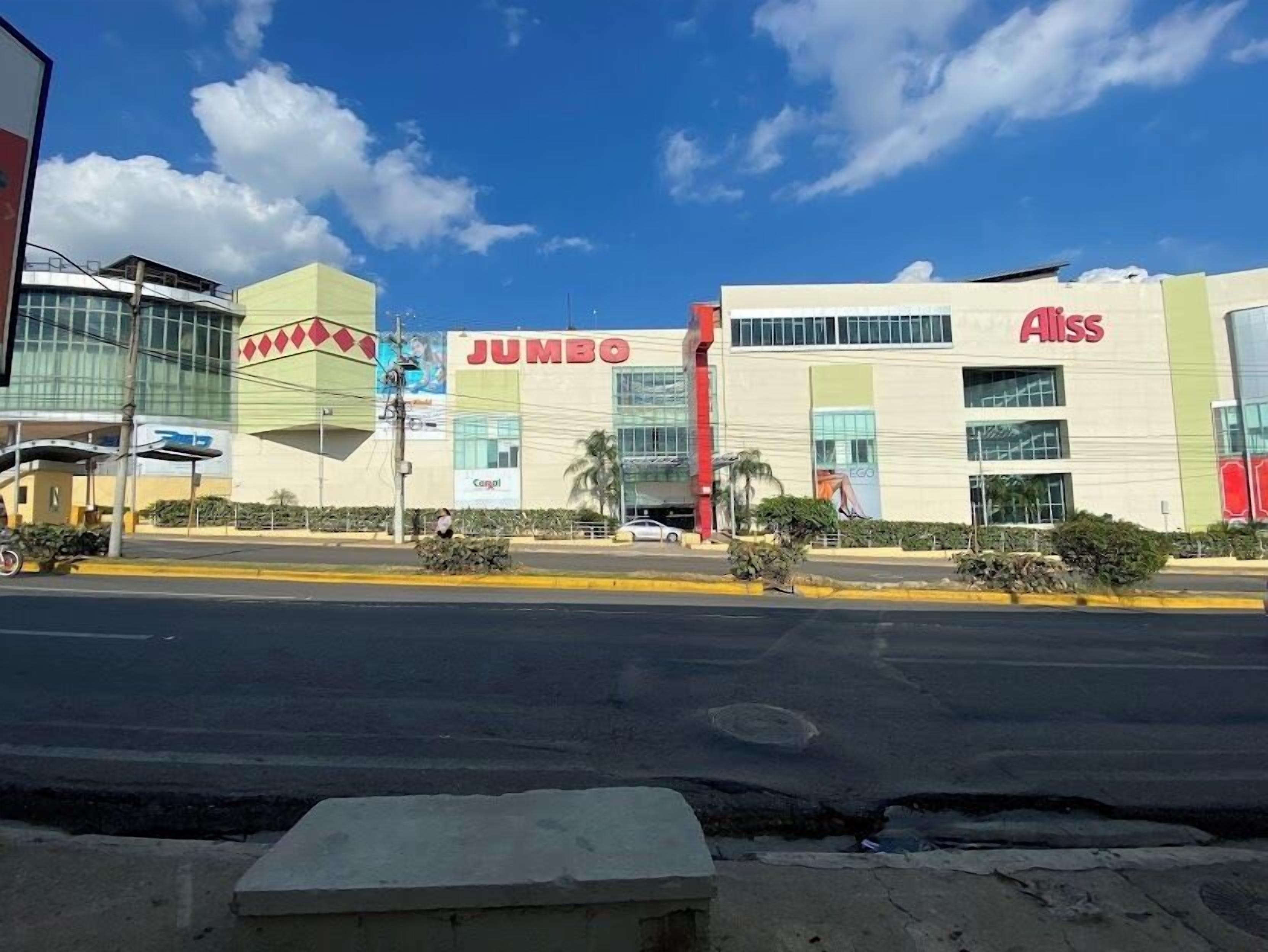 A commercial building with 'JUMBO' and 'Alliss' signage, featuring a modern architectural design with large windows and a flat roof.