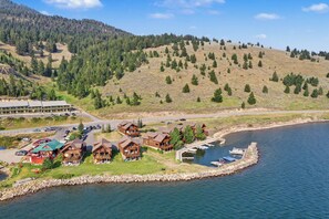 A lakeside lodge with multiple cabins, a dock, and a road leading to a parking area. - Relaxing Lakeside Getaway on Beautiful Hebgen Lake! HOT TUB with lake views- Beachside Lodge (West Yellowstone)