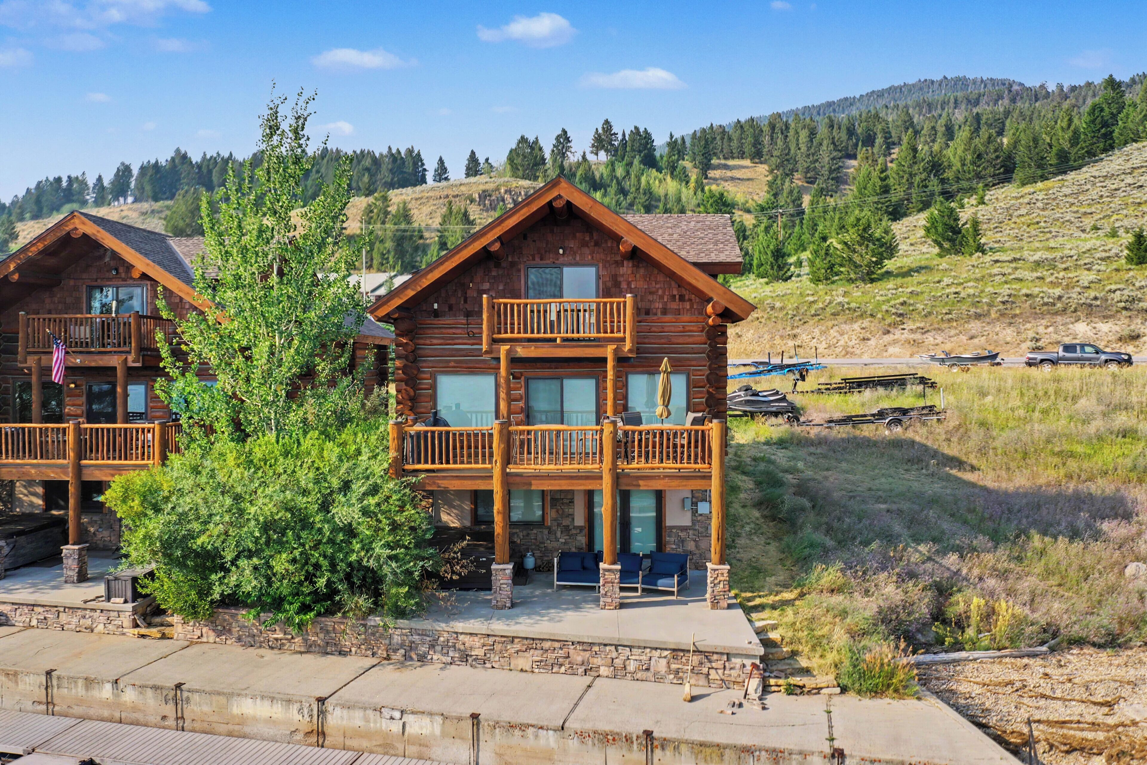 A log cabin with a balcony and a stone foundation.