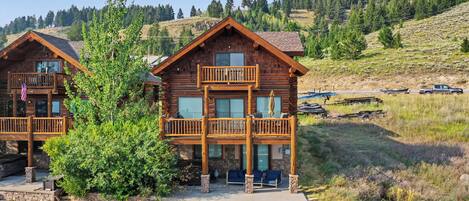 A log cabin with a balcony and a stone foundation.