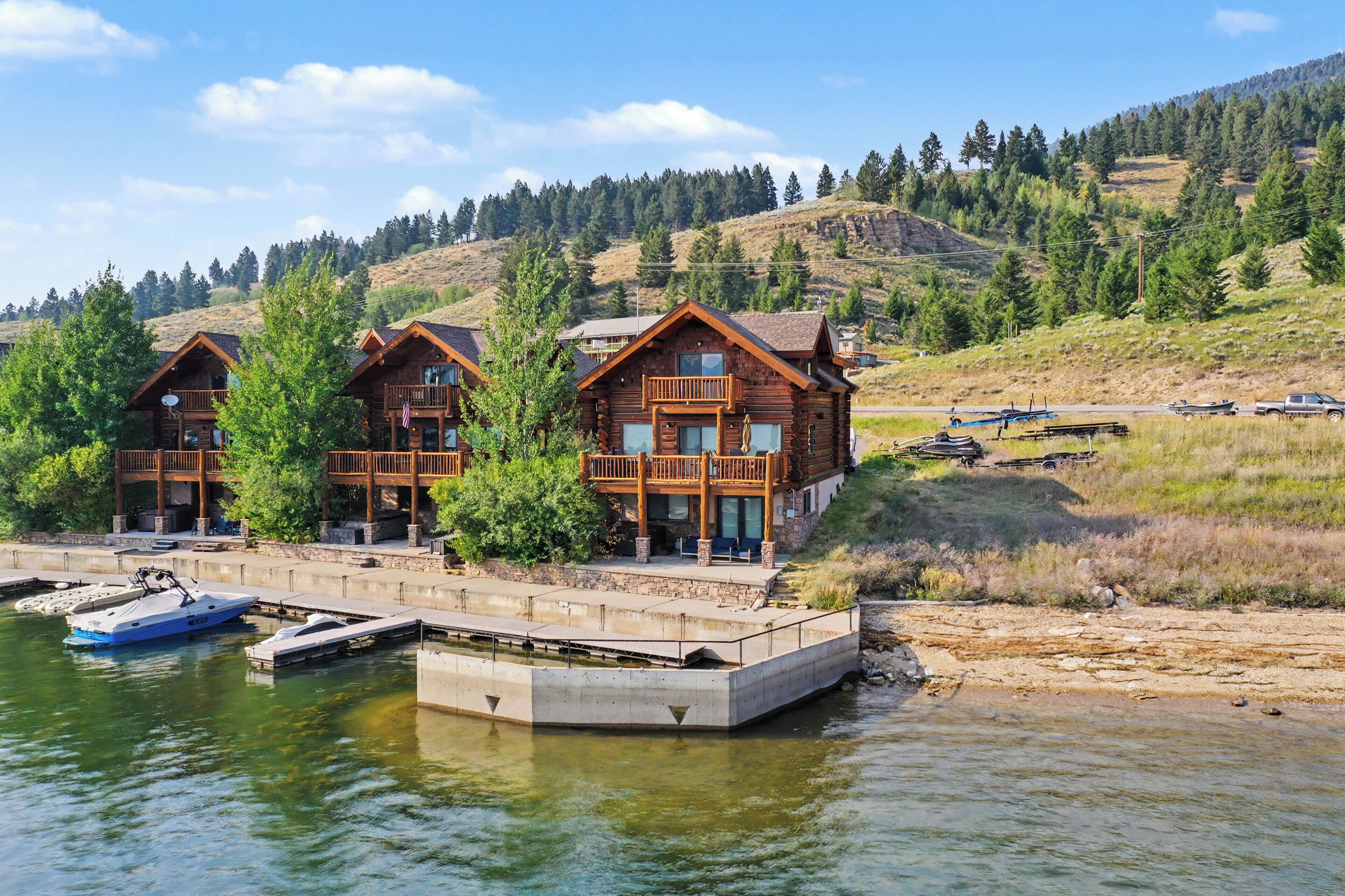A log cabin with a dock and a boat.