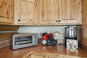 A kitchen with wooden cabinets, a toaster oven, a coffee maker, and a kettle. - Relaxing Lakeside Getaway on Beautiful Hebgen Lake! HOT TUB with lake views- Beachside Lodge (West Yellowstone)