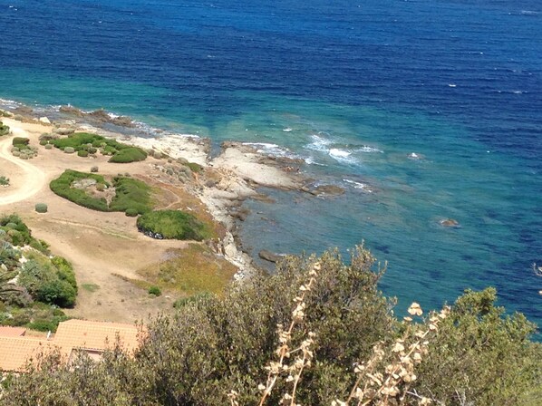 A coastal landscape with rocky shores, clear blue water, and green vegetation. - Mini Villa with a breathtaking view of the sea (Lumio)
