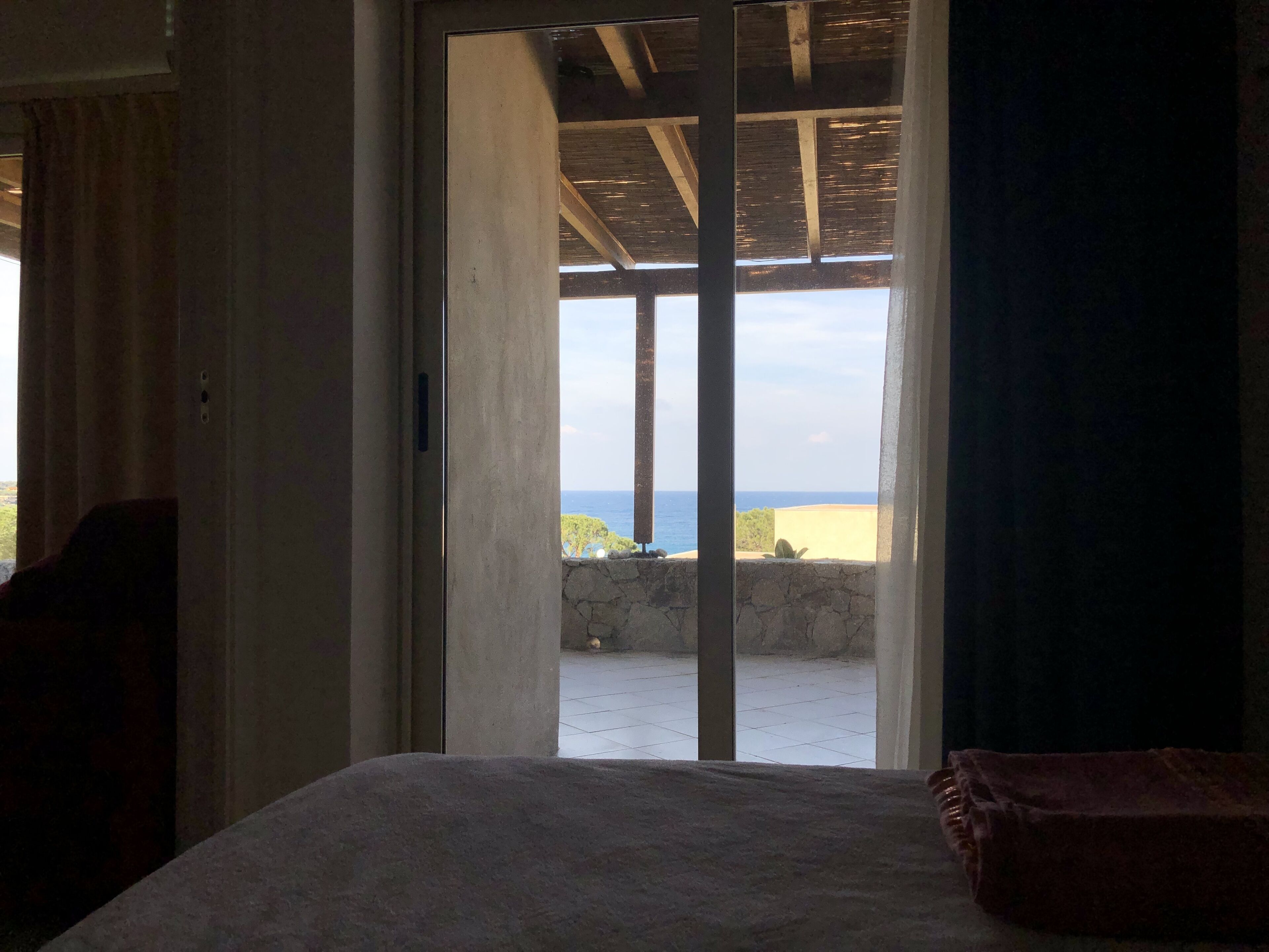 Ein Schlafzimmer mit Bett, Meerblick und einem Balkon.
