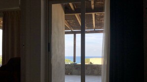 A bedroom with a bed, a view of the sea, and a balcony. - Mini Villa avec imprenable vue sur la mer (Lumio)