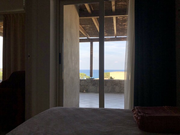 A bedroom with a bed, a view of the sea, and a balcony. - Mini Villa with a breathtaking view of the sea (Lumio)