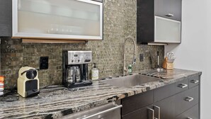 Cozinha com cafeteira, pia e porta-facas.