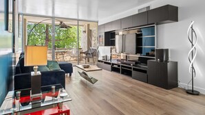 Uma sala de estar moderna com uma televisão grande, sistema de entretenimento embutido e uma mesa de centro de vidro.