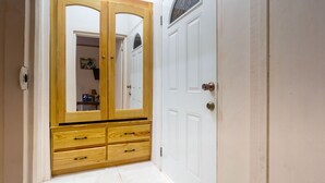 A hallway with a wooden wardrobe featuring two mirrored doors and a small window. - Eleven30 Luxury Apartments  (Negril)