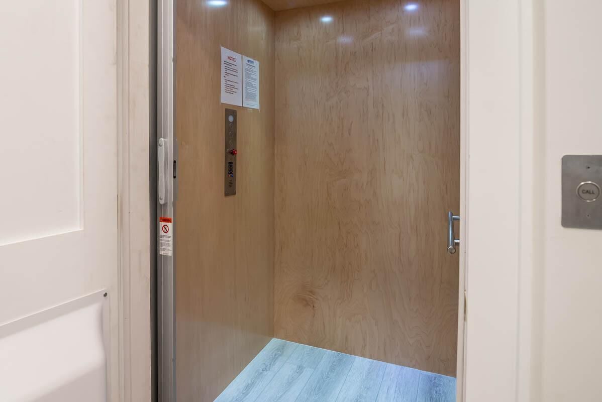 A wooden door with a metal handle and a notice sign.