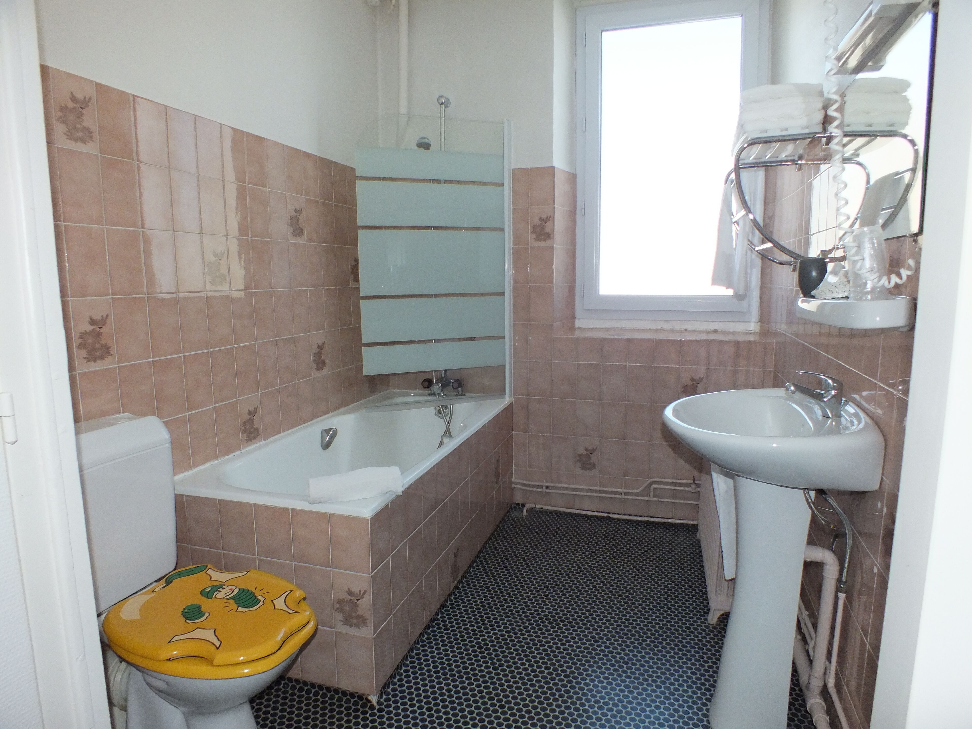 Un baño con inodoro, bañera y lavamanos.