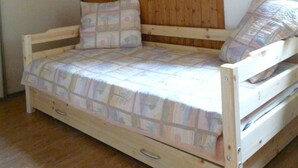 A single wooden bed with a quilted bedspread and two pillows, a wooden ceiling, and a white wall. - Châtel - Roitet : 3P apartment, quiet, breathtaking view in Chalet Lou P'nots  (Châtel)