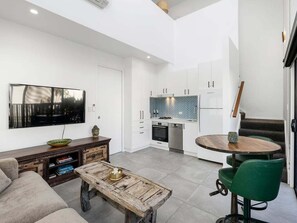 Et moderne køkken med hvide skabe, et bølgemønstret backsplash og en integreret ovn.