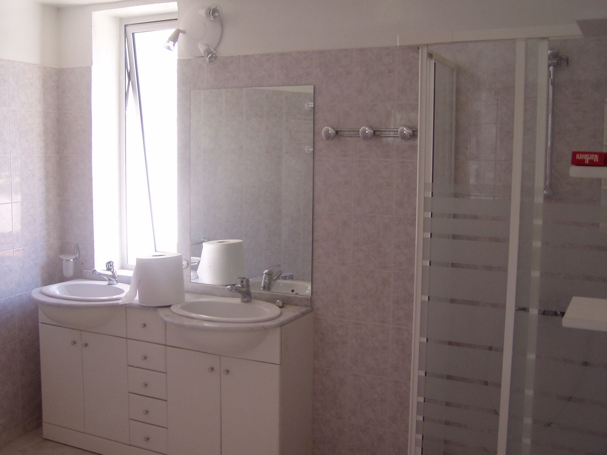 Un baño con dos lavamanos, un espejo y una ducha.
