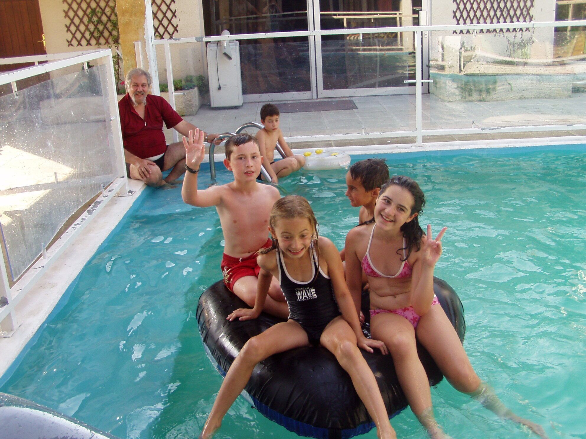 A swimming pool with inflatable rings and people enjoying the water.