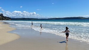 Een strand met heldere luchten en rustig water.