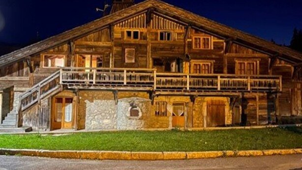 A wooden building with multiple stories, a balcony on the second floor, and a stone foundation. - Central 3-BR Apartment for 6 with WiFi, Parking & Spa Access (Les Carroz d'Arâches)