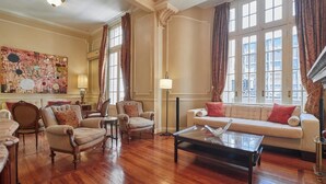 Un salón amplio con suelo de madera, un conjunto de sofá y una mesa de centro.