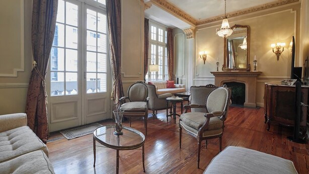 Un salón amplio con chimenea, asientos cómodos y ventanas grandes.