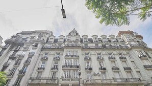 Un edificio de varias plantas con arquitectura clásica, que presenta balcones y amplias ventanas.