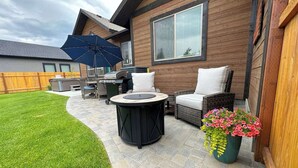 A patio area with outdoor furniture, a grill, and a potted plant. - Luxurious Family Home in Driggs - Hot Tub (Driggs)