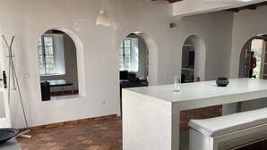 A spacious room with white walls, a large white table, and a bench. There are arched windows allowing natural light. - Modern villa with swimming pool just è kms from Essaouira (Essaouira)
