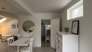 Cocina compacta y moderna con comedor, horno integrado y ventana que proporciona luz natural.