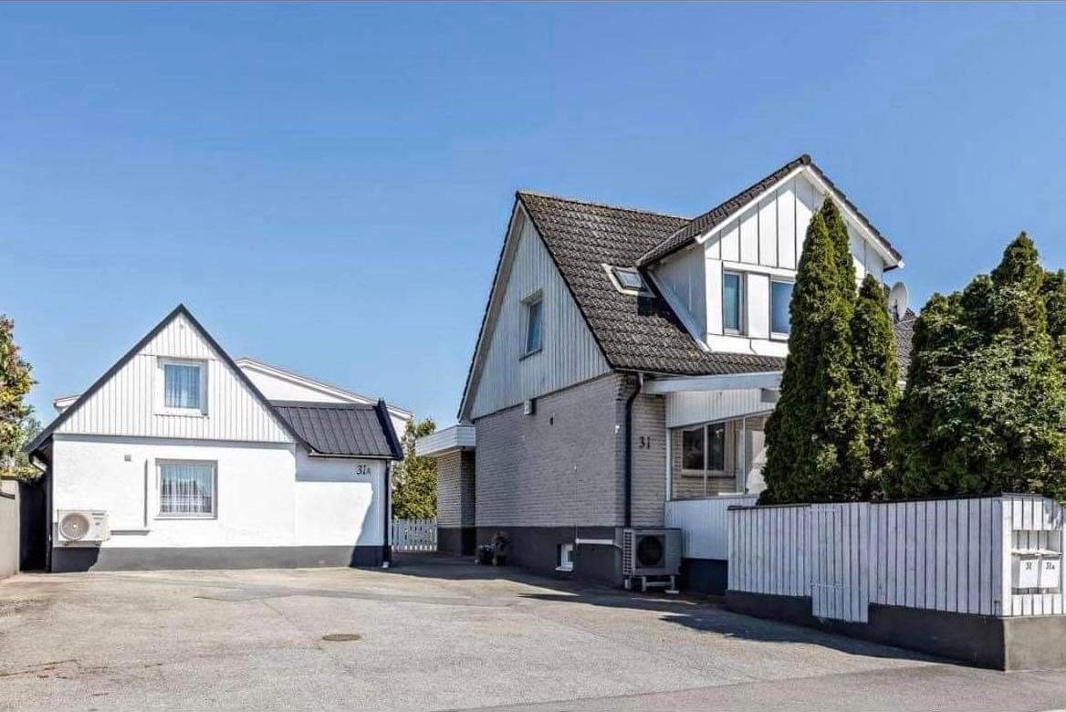 Et toetagers hus med en stor indkørsel og en lukket have.