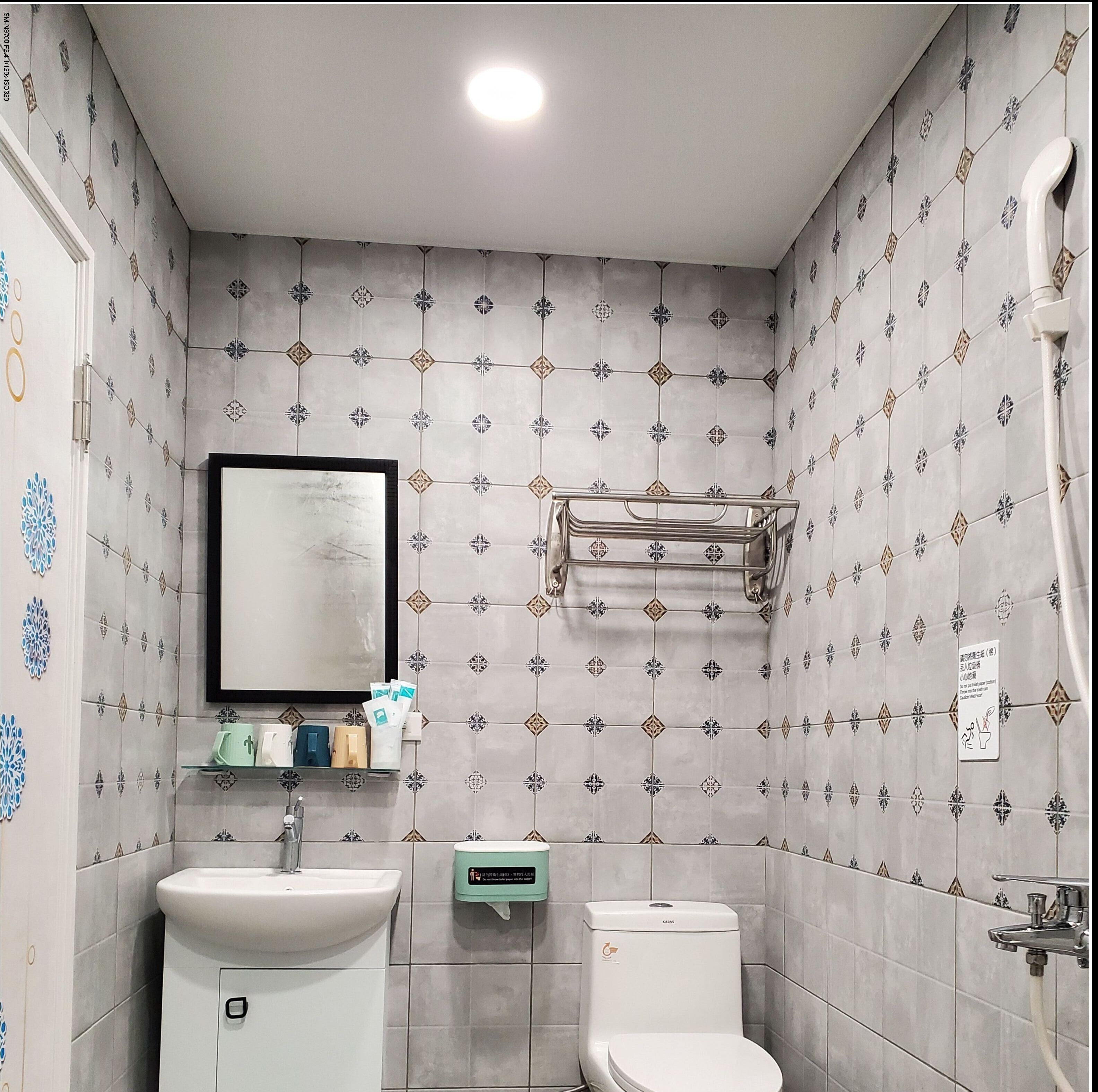 A bathroom with a sink, toilet, and a towel rack.