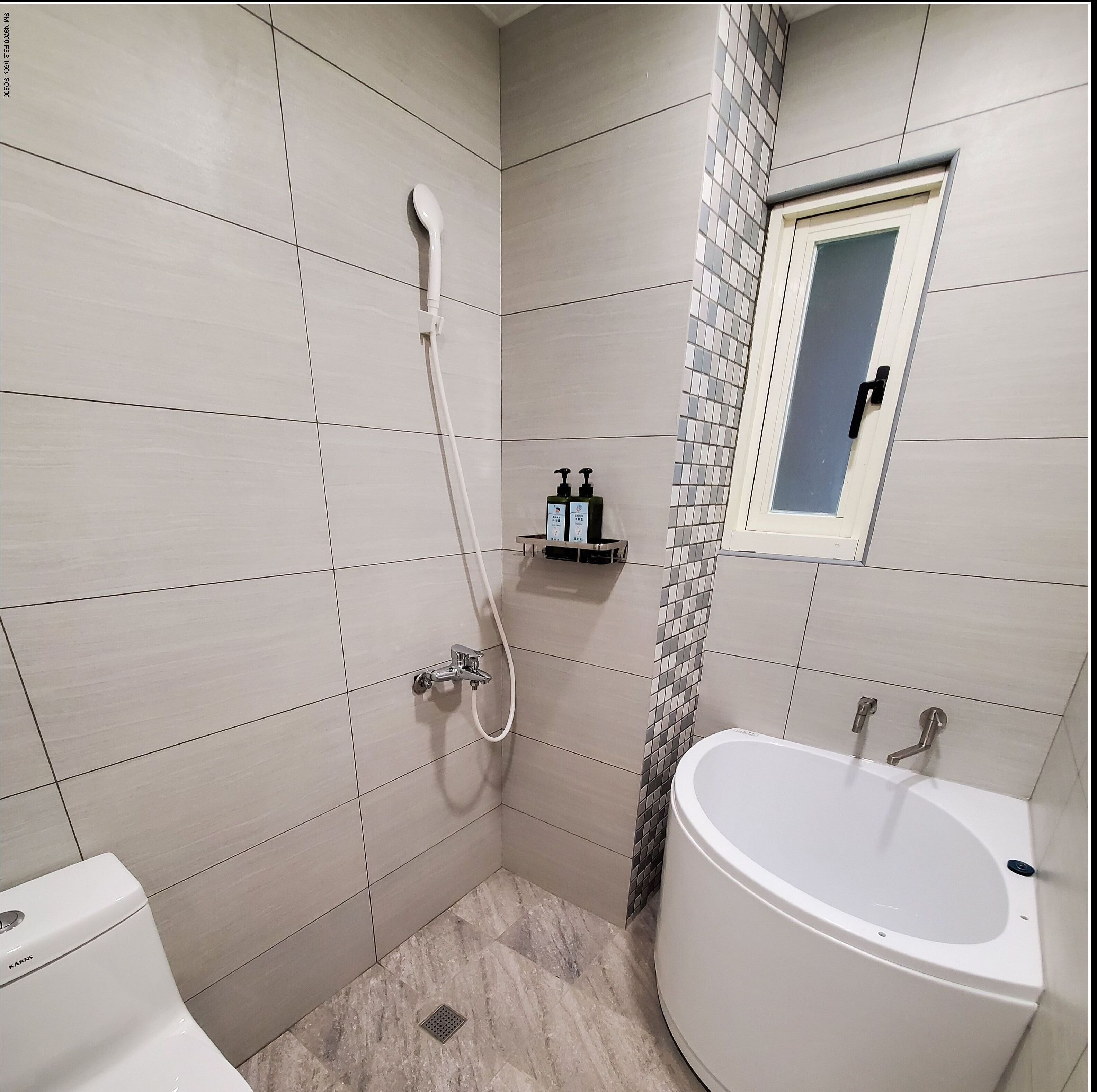 Une salle de bain moderne équipée d’une douche, de toilettes et d’une baignoire.