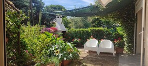 A garden with potted plants, a white structure, and two white chairs. - Villino del Sorriso - Three-Bedroom Apartment Near the Ocean with Amenities, Garden, and Parking (Marcelli)