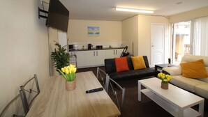 A compact living space with a dining table, a sofa, a coffee table, and a kitchen area. - Annex St Ann's (Rotherham)