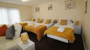 A hotel room with two beds, a sofa, a nightstand, and a lamp. - Annex St Ann's (Rotherham)