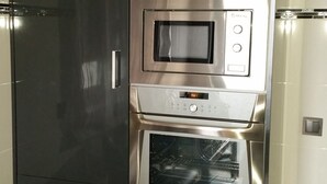 A kitchen with a built-in oven, microwave, and a stainless steel refrigerator. - Casa Pinheiro 5 minutes from Barcelos city center (Arcozelo)