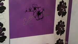 A bedroom with a purple bedspread, matching pillows, and a wall with floral designs. - Casa Pinheiro 5 minutes from Barcelos city center (Arcozelo)