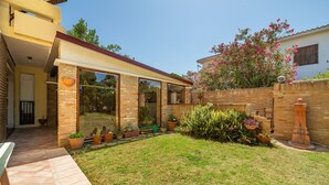 A residential property with a patio, brick exterior, and a garden with potted plants. - Villa 'Nuràya' with Sea View and Private Terrace (Capoterra)