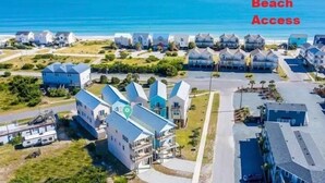 Un quartier résidentiel situé sur la côte, avec des maisons à proximité de la plage, indiqué par une épingle verte sur la carte.
