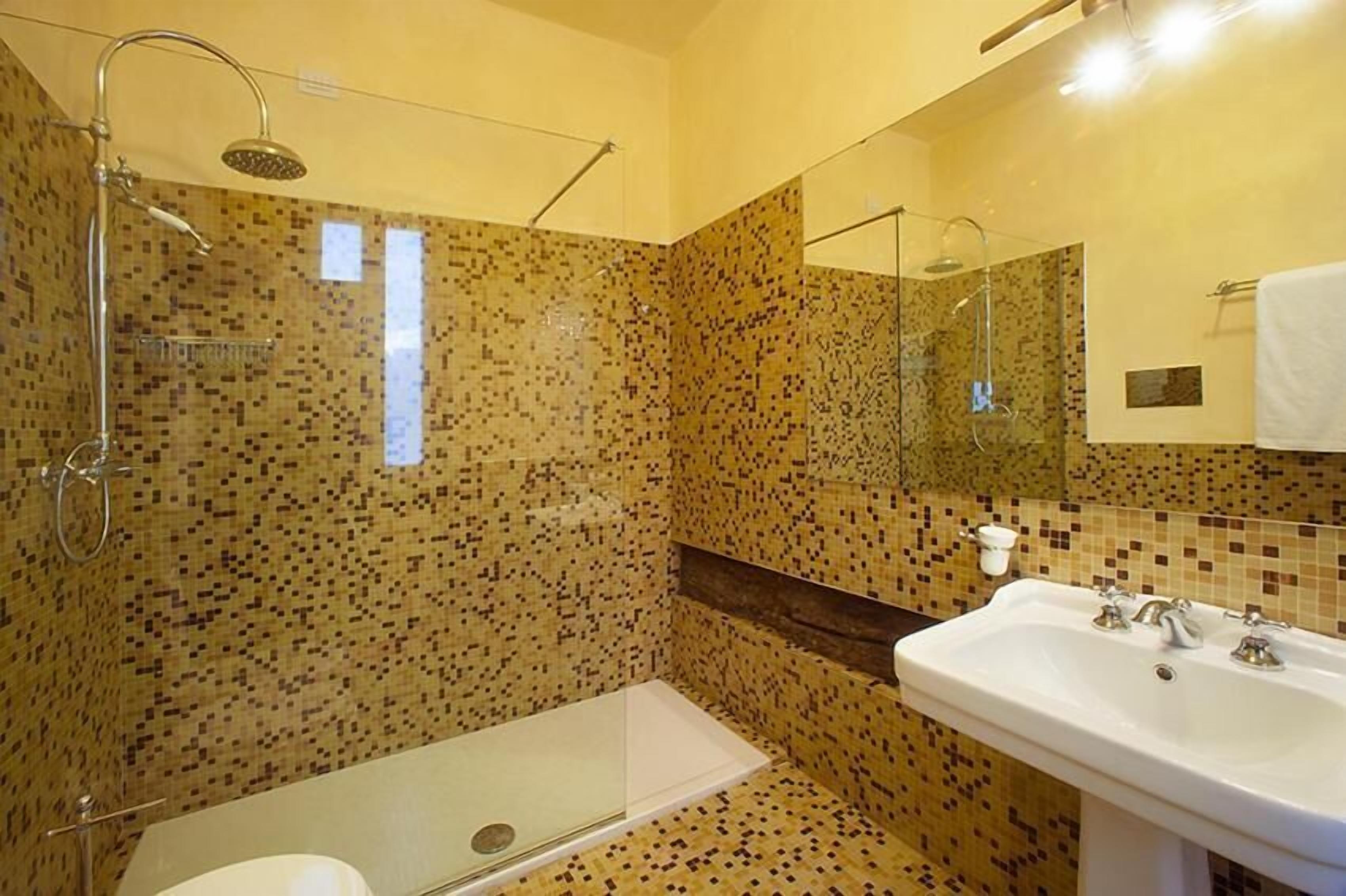 Un baño con ducha, lavamanos e inodoro.