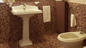 A bathroom with a pedestal sink, a toilet, and a bidet. There are two towels hanging on hooks, and a mirror above the sink. - Relais Vimercati (Crema)
