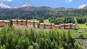 Eine Reihe von Holzhütten vor einer Bergkulisse.