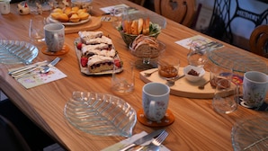 Taula de menjador preparada amb diversos aliments, estris i recipients de vidre.