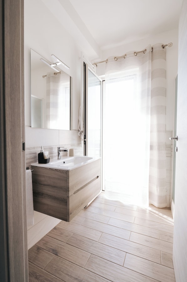 Deluxe Quadruple Room | Bathroom | Shower, rainfall showerhead, free toiletries, hair dryer