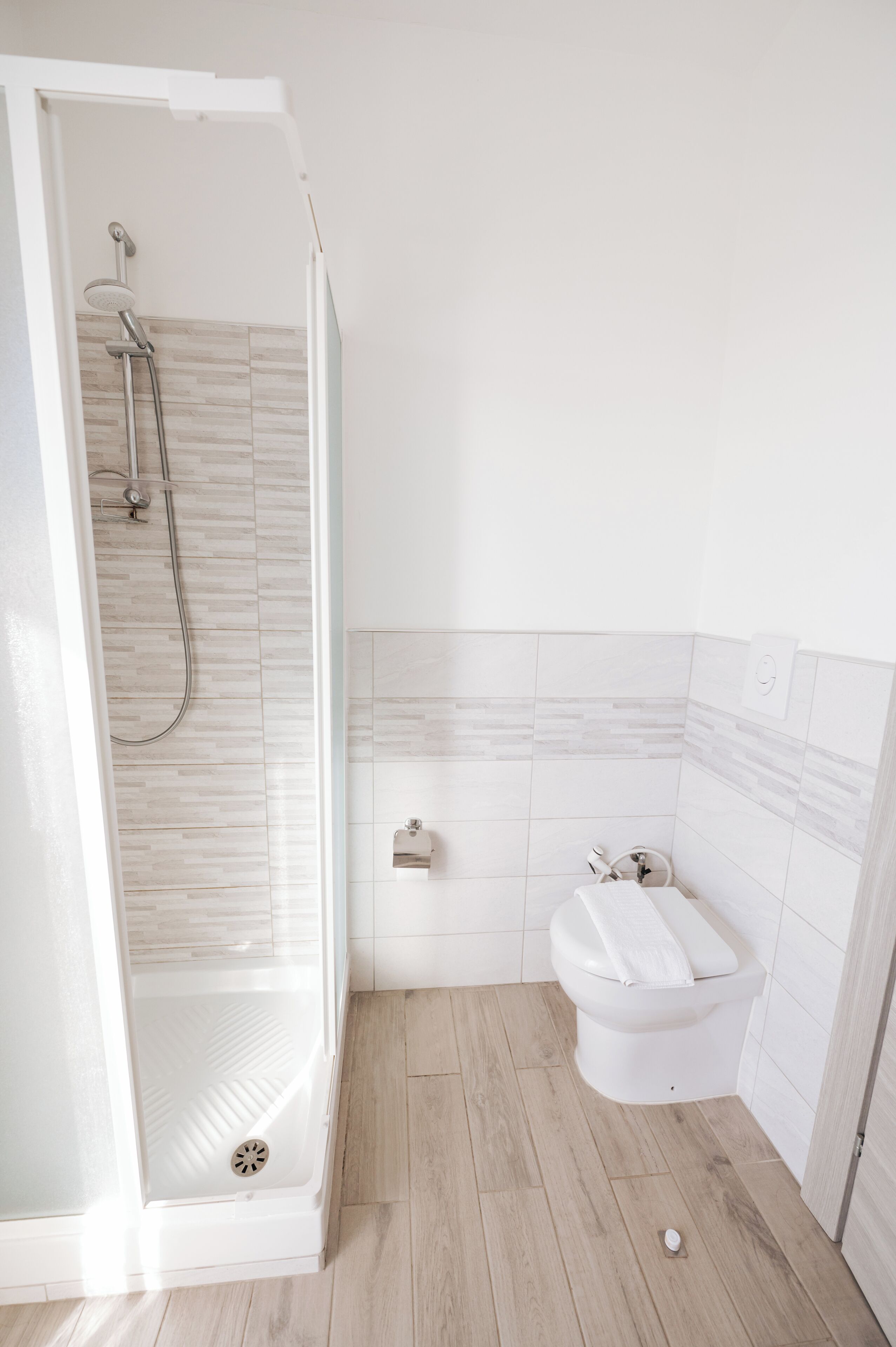 Ein Badezimmer mit einer Duschkabine, einer Toilette und einem Waschbecken.